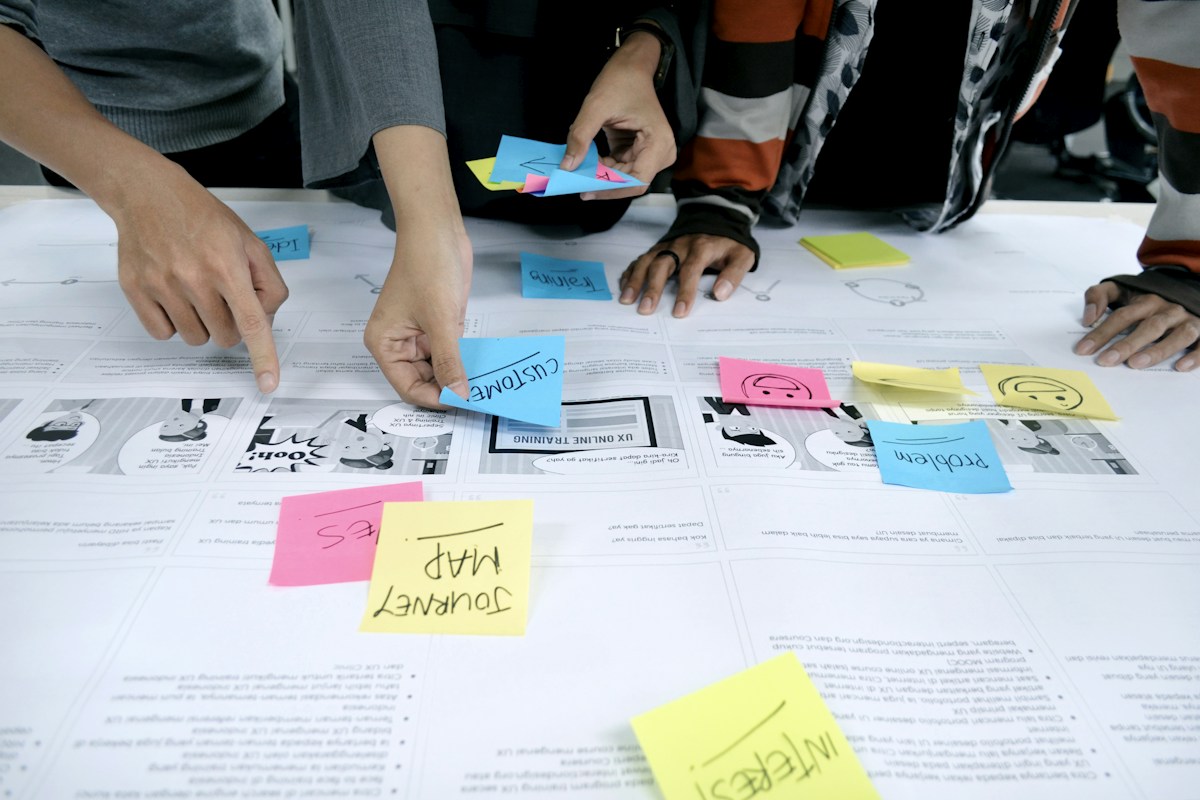 Hands arranging wireframes and notes during product planning